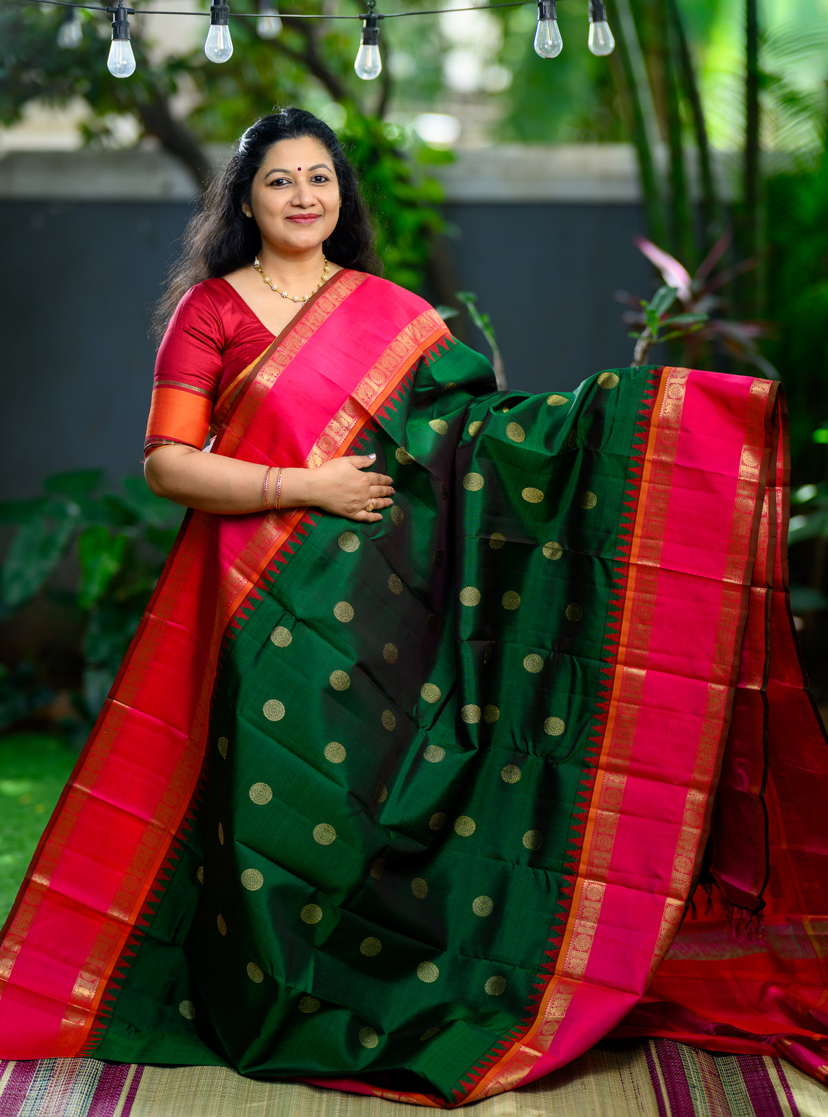 A grand pure silk, pure zari Korvai Kanchivaram in a beautiful bottle green body, contrasted with a vibrant pink border.