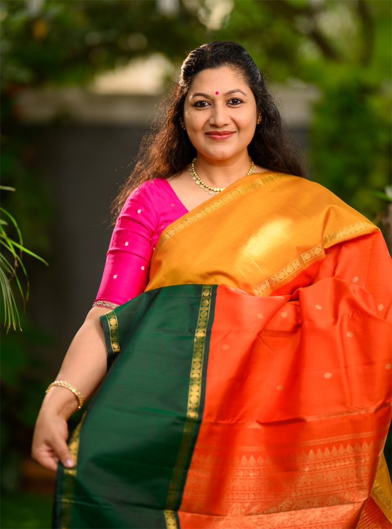 Pure silk, pure zari Ganga Jamuna korvai Kanchivaram in a striking combination of orange on the body, with bottle green and mustard on either side.