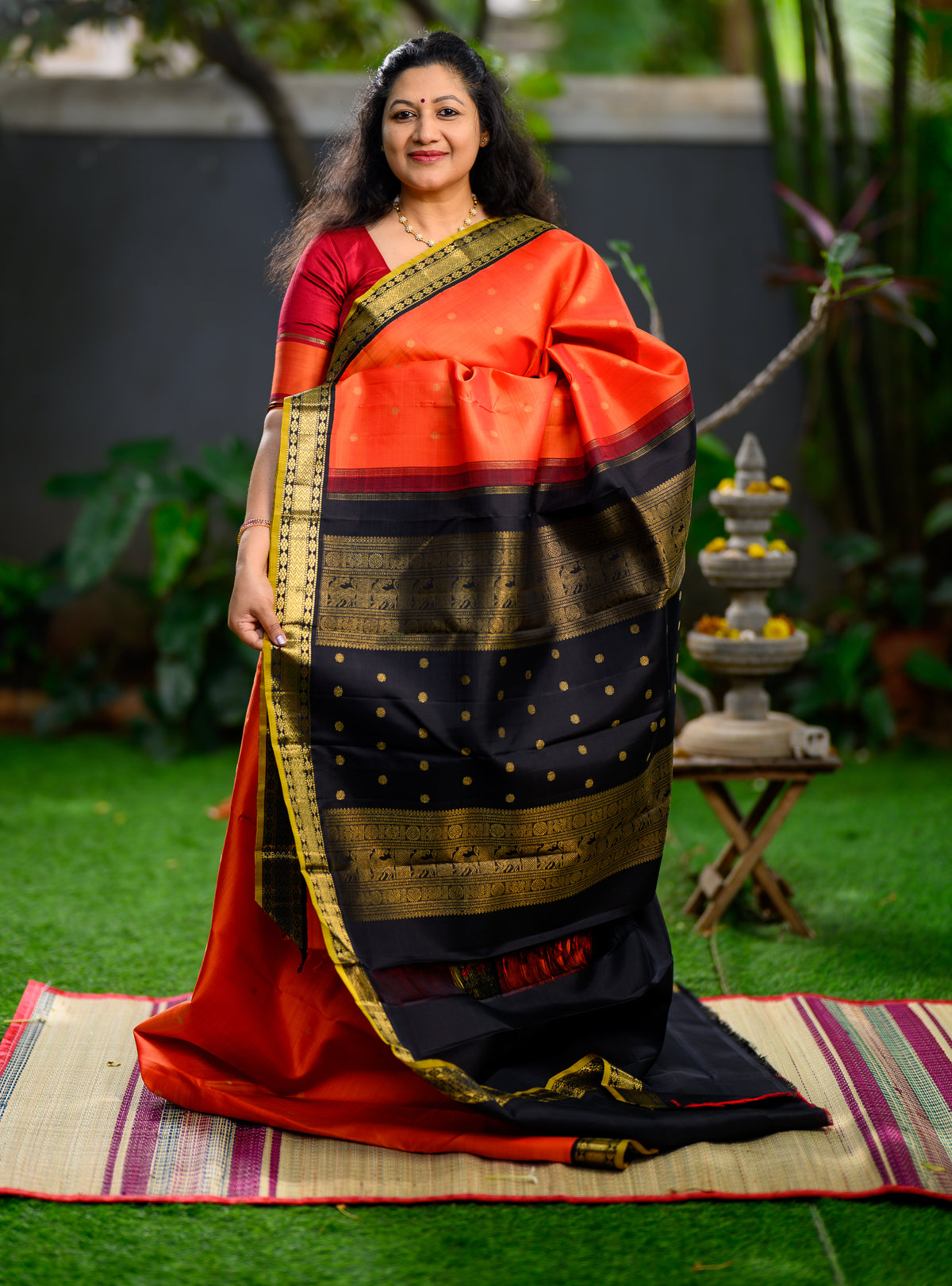 Pure silk, pure zari Korvai Kanchivaram in a bright sun-orange shade, beautifully contrasted with a classic black border.