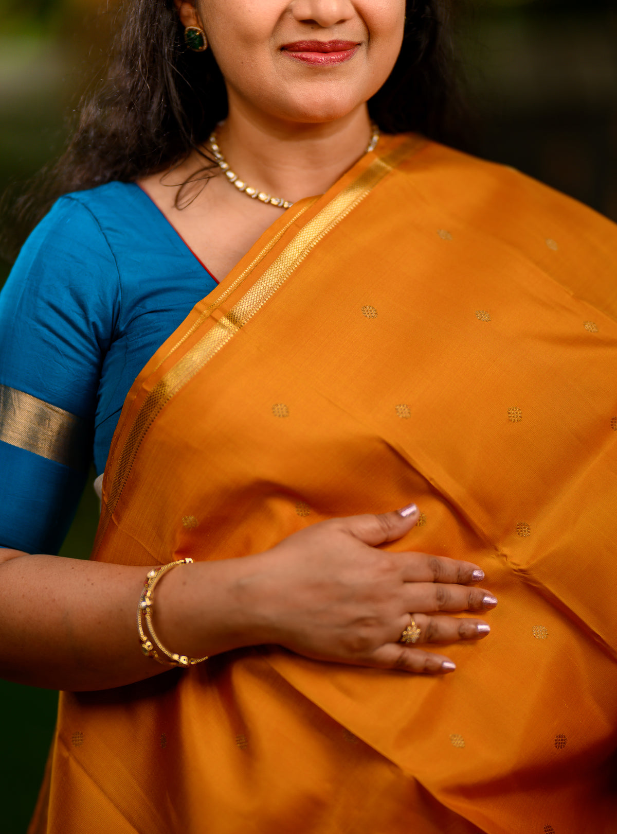 This is a gorgeous pure silk, pure zari Beetu Butta Kanchivaram in a rich mustard shade paired with a beautiful violet pallu.