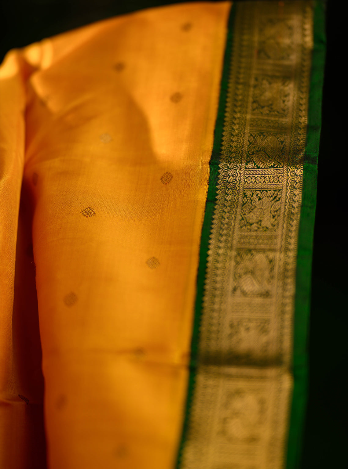 A beautiful pure silk, pure zari korvai kanjivaram in an evergreen combination of turmeric yellow body and emerald green border.