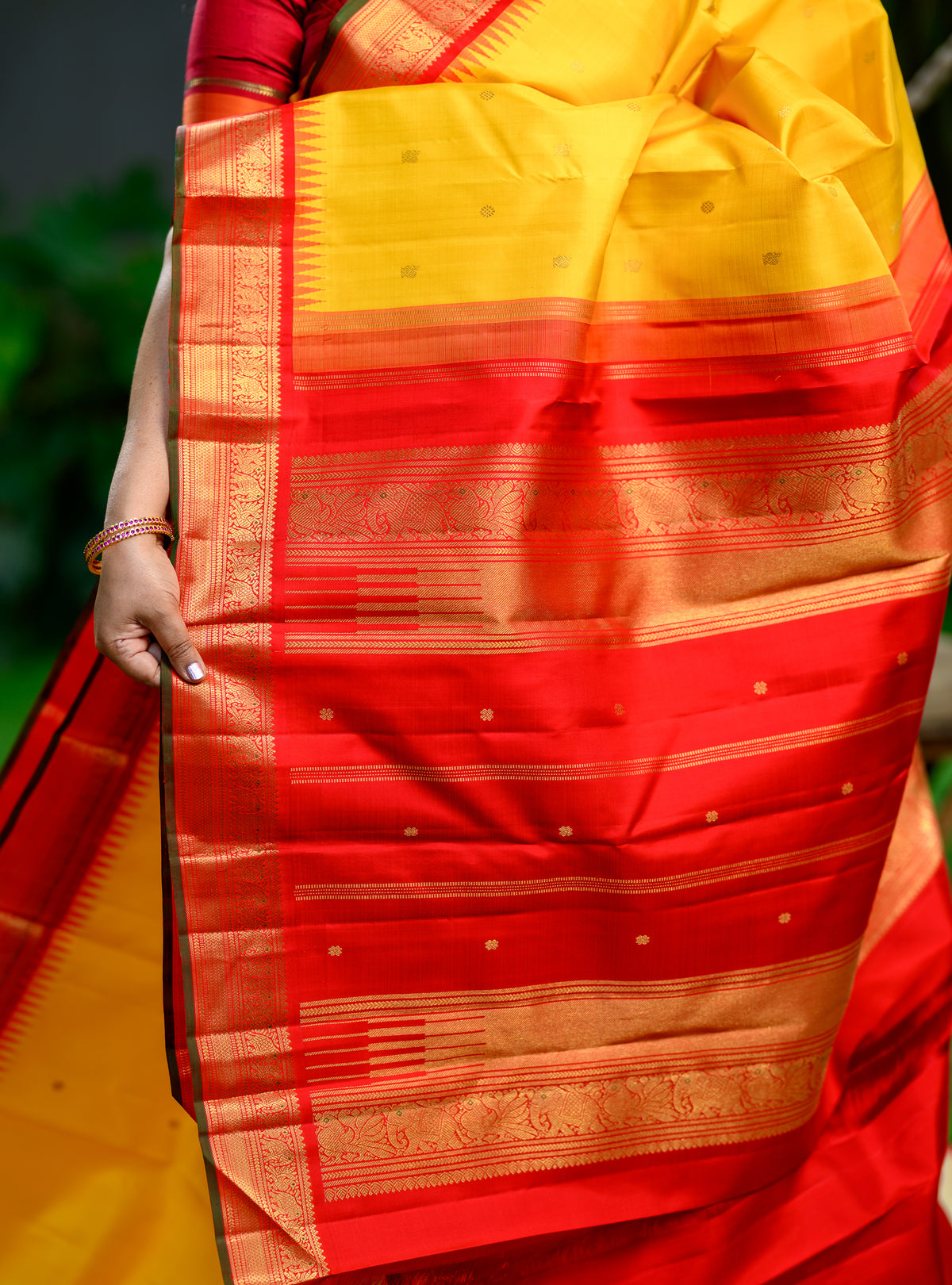 Pure silk, pure zari Korvai Kanchivaram in a beautiful turmeric yellow body, featuring elegant peacock and tiny Kamalam buttas.