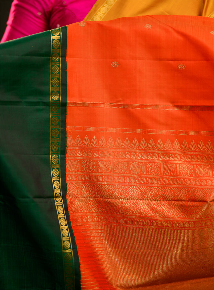Pure silk, pure zari Ganga Jamuna korvai Kanchivaram in a striking combination of orange on the body, with bottle green and mustard on either side.