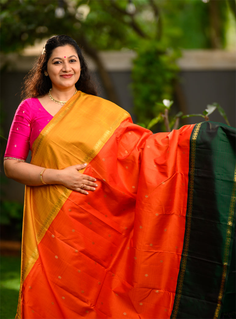Pure silk, pure zari Ganga Jamuna korvai Kanchivaram in a striking combination of orange on the body, with bottle green and mustard on either side.
