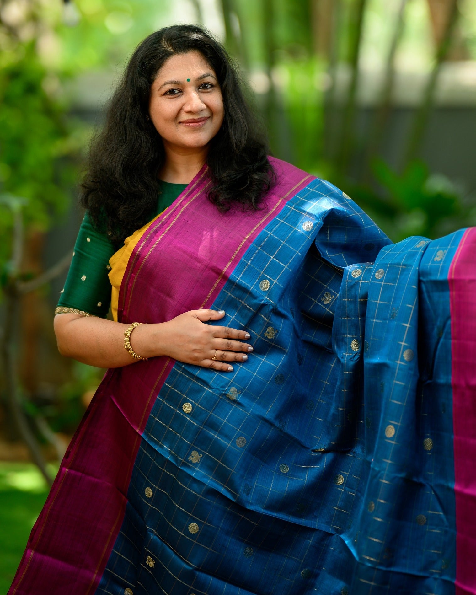 A striking zari kattam Kanjivaram in a rich teal blue and magenta combination.