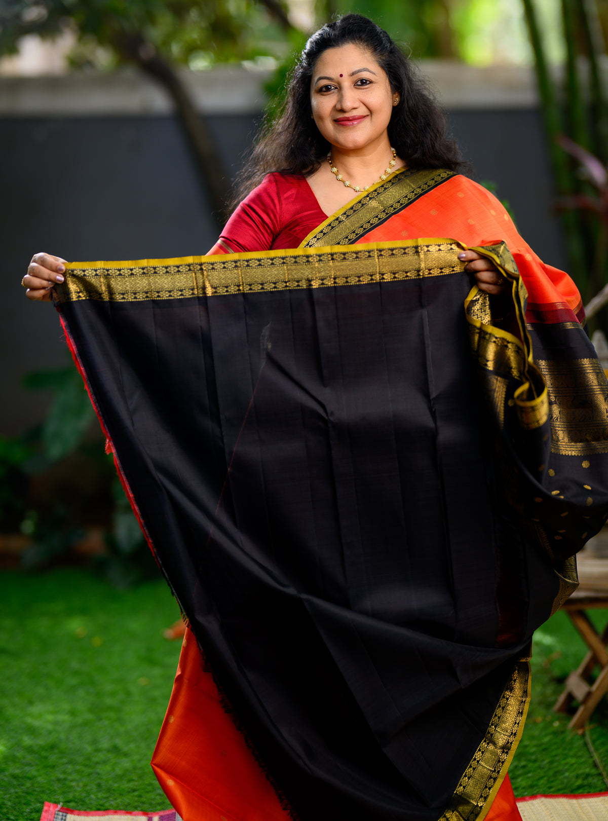 Pure silk, pure zari Korvai Kanchivaram in a bright sun-orange shade, beautifully contrasted with a classic black border.