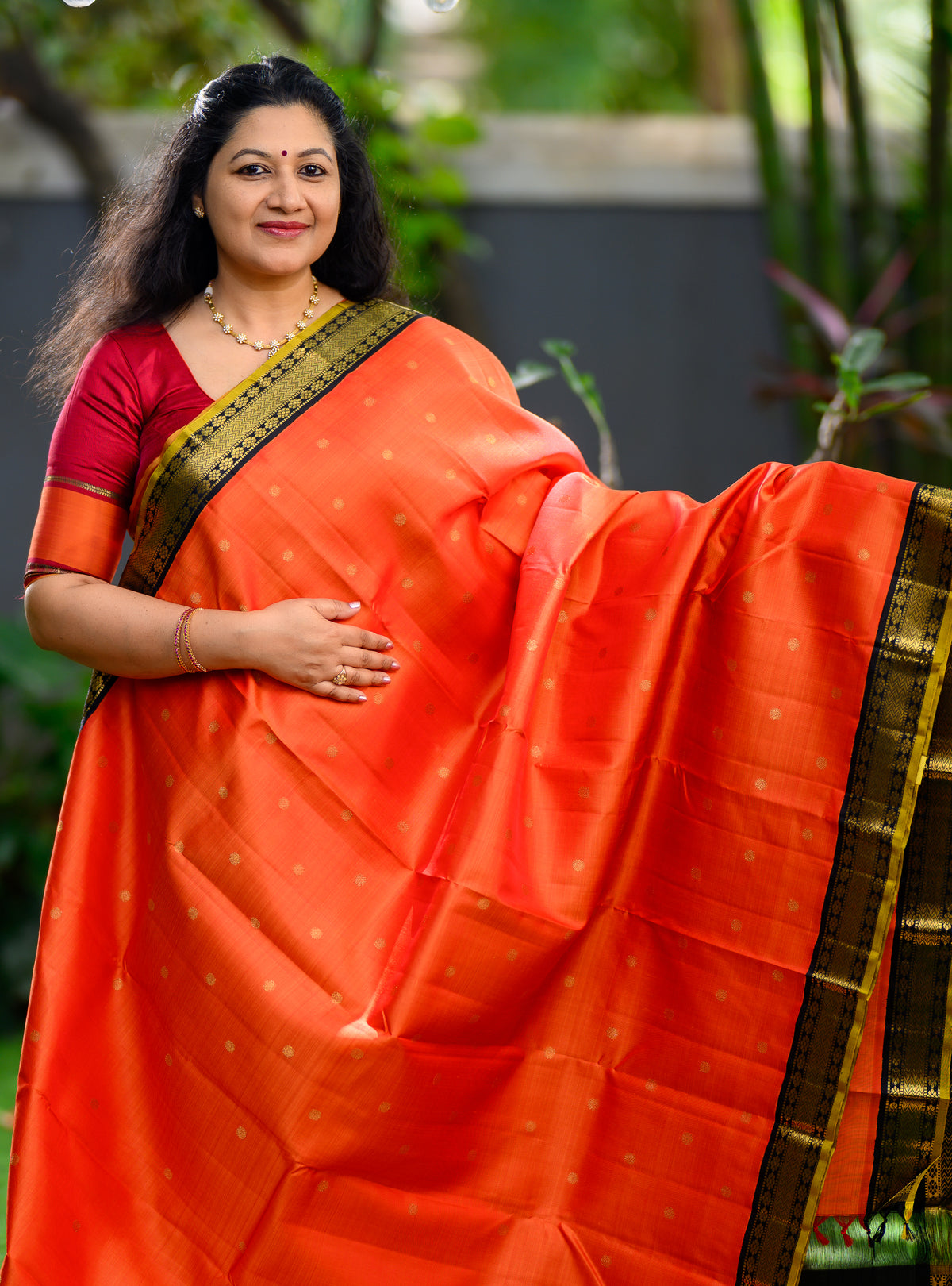 Pure silk, pure zari Korvai Kanchivaram in a bright sun-orange shade, beautifully contrasted with a classic black border.