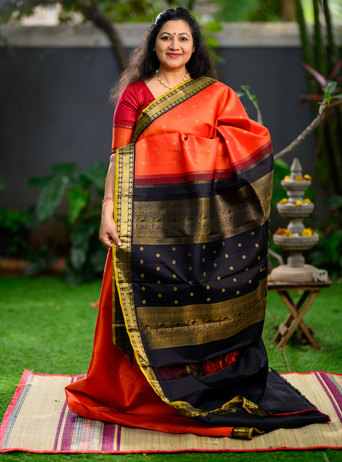 Pure silk, pure zari Korvai Kanchivaram in a bright sun-orange shade, beautifully contrasted with a classic black border.
