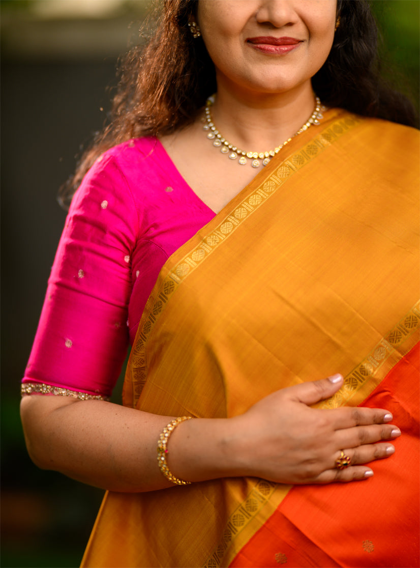 Pure silk, pure zari Ganga Jamuna korvai Kanchivaram in a striking combination of orange on the body, with bottle green and mustard on either side.