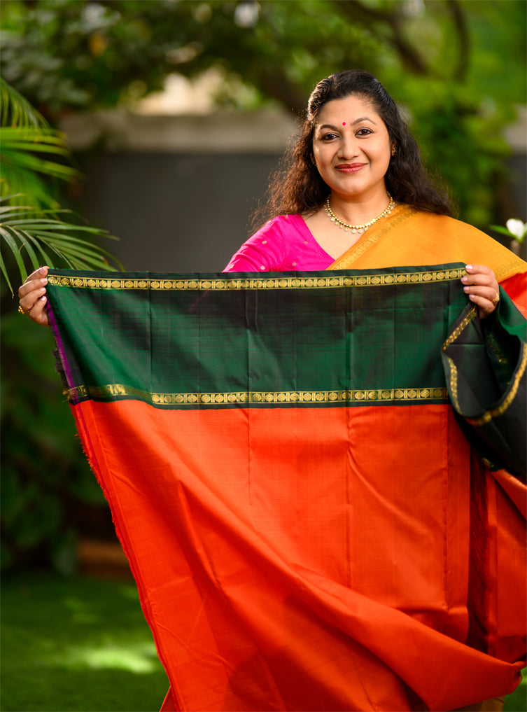 Pure silk, pure zari Ganga Jamuna korvai Kanchivaram in a striking combination of orange on the body, with bottle green and mustard on either side.