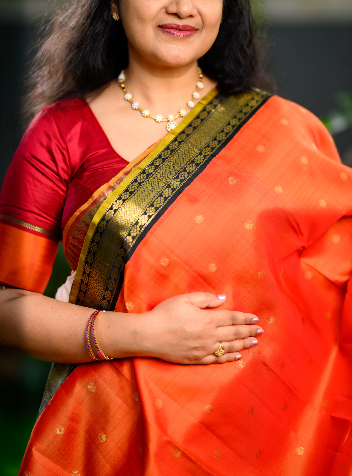 Pure silk, pure zari Korvai Kanchivaram in a bright sun-orange shade, beautifully contrasted with a classic black border.